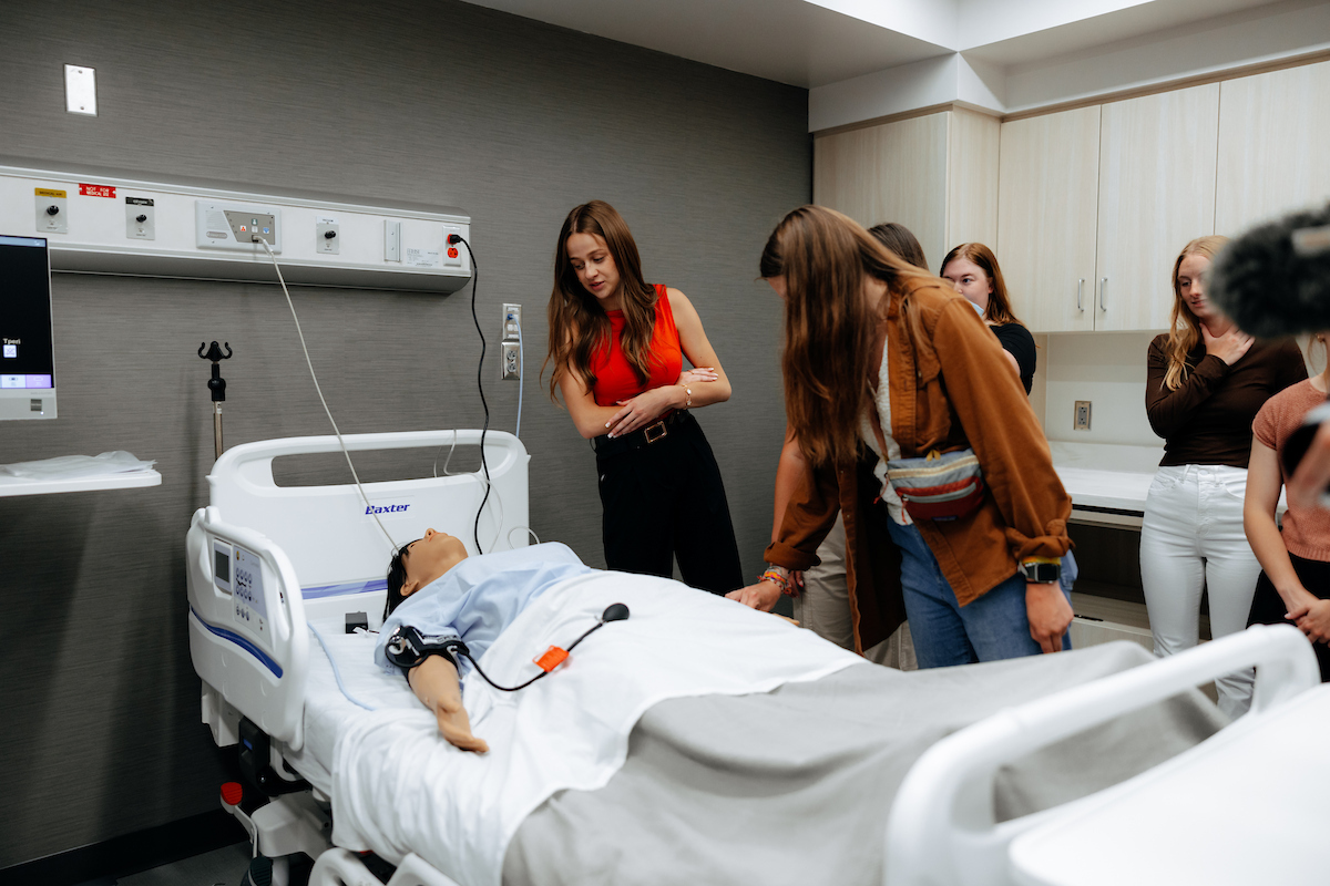 Nursing students checking out medical manikin