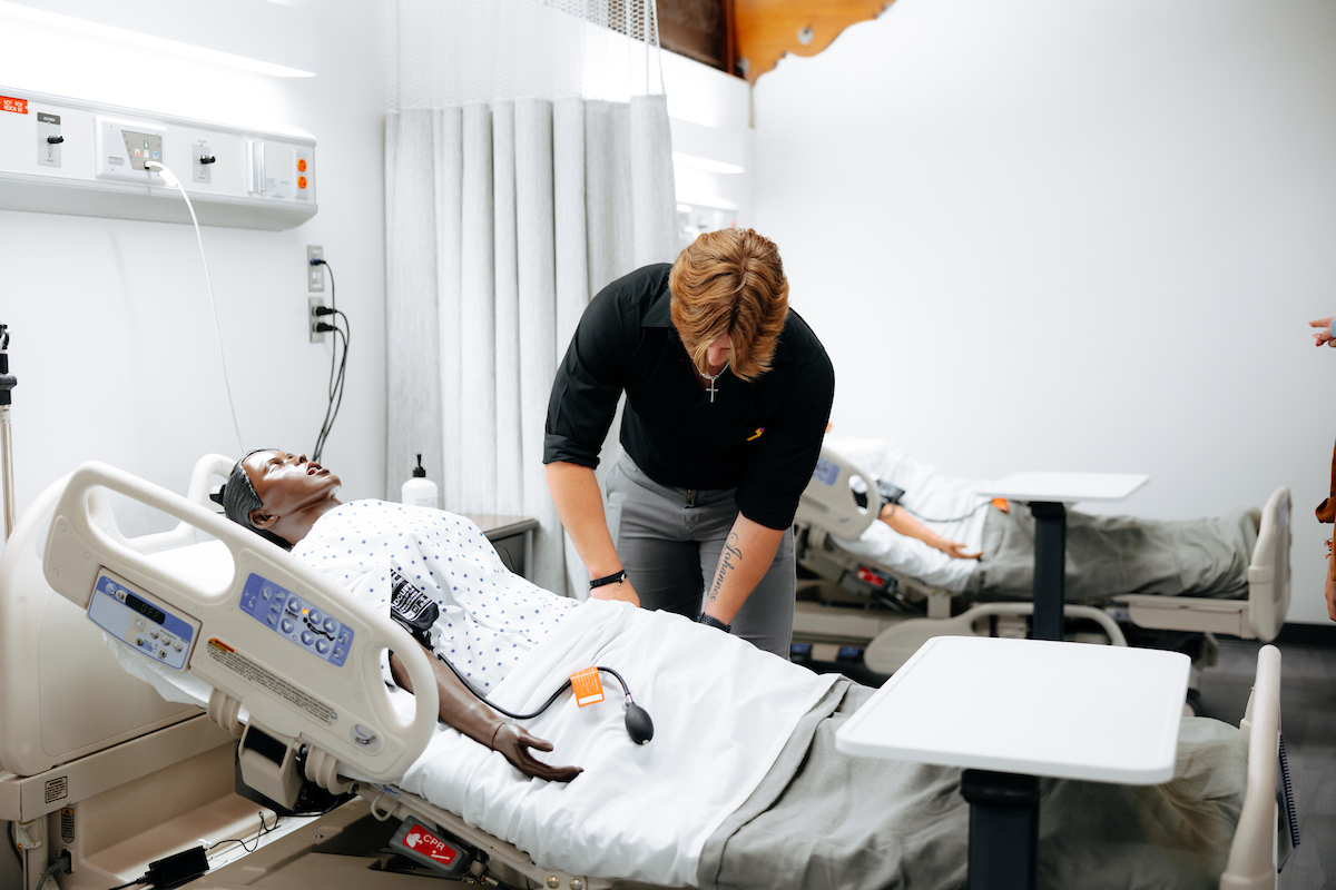 Student checking on medical manikin