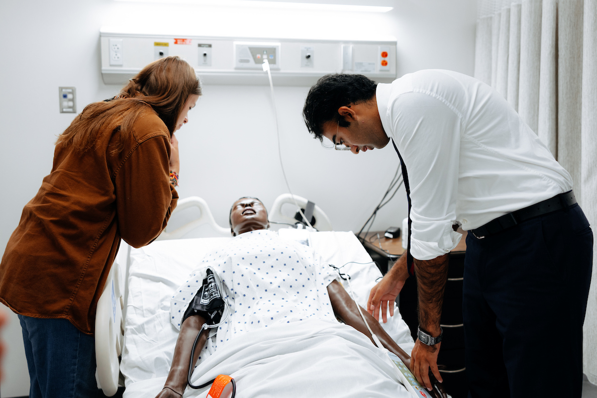 UNI nursing students look at medical manikin