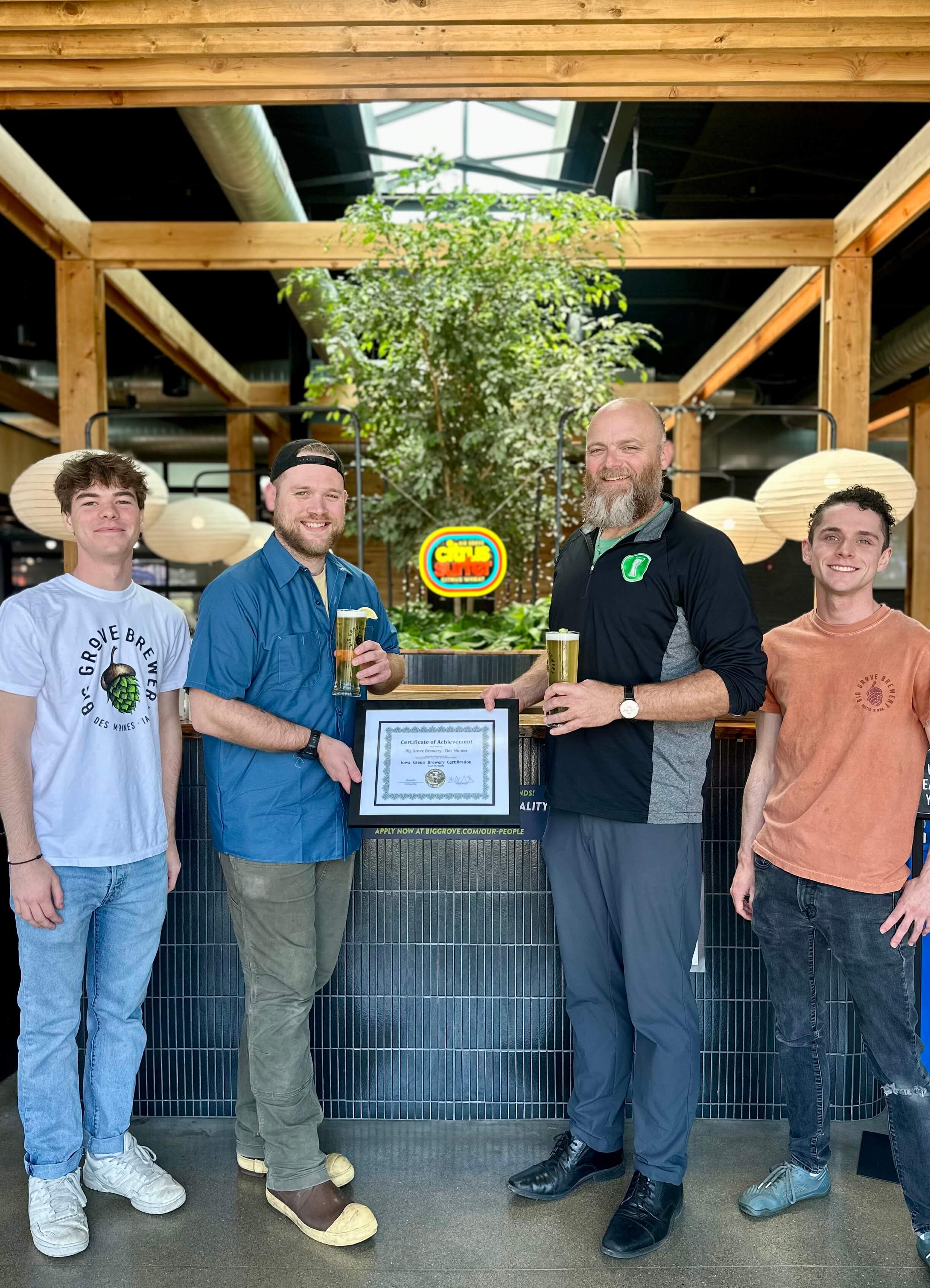 Staff members of Big Grove Des Moines accept their Iowa Green Brewery Certification