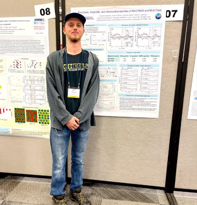 Student standing front of his work at conference