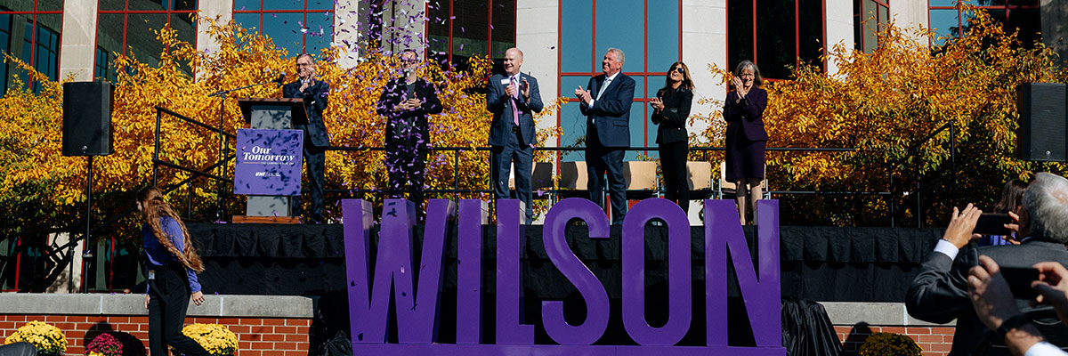 David & Holly Wilson, Dean Leslie Wilson, Jim Jermier and President Mark Nook applauding as confetti blows in the wind after the historic gift announcement