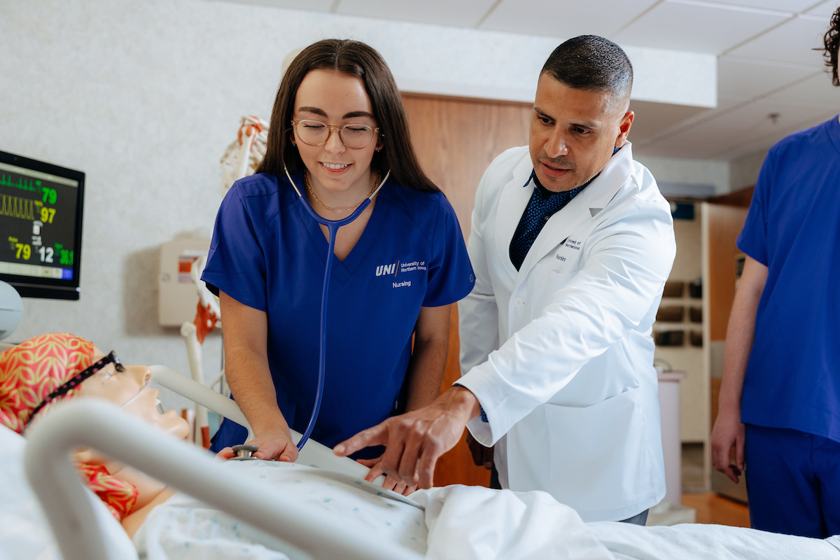 Jimmy Reyes helps student examine simulated patient