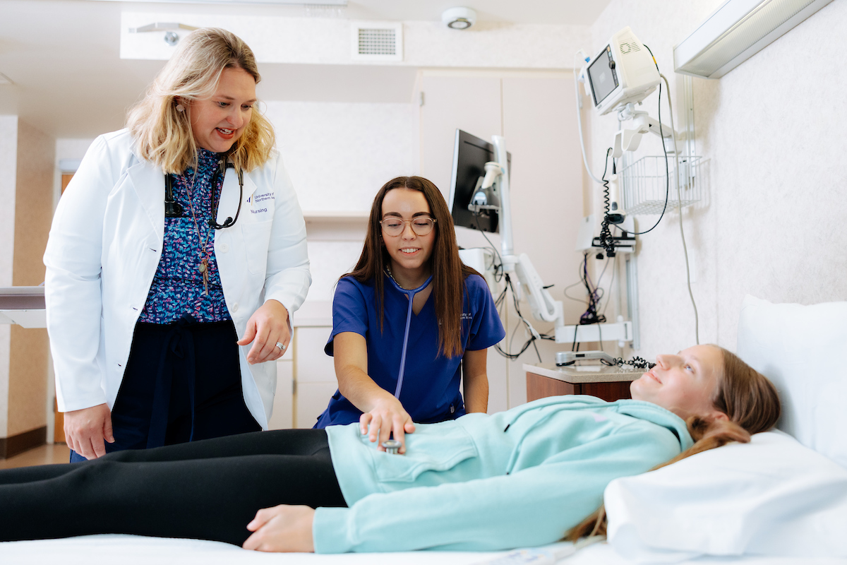 Carrie Hollerud helps student examine patient