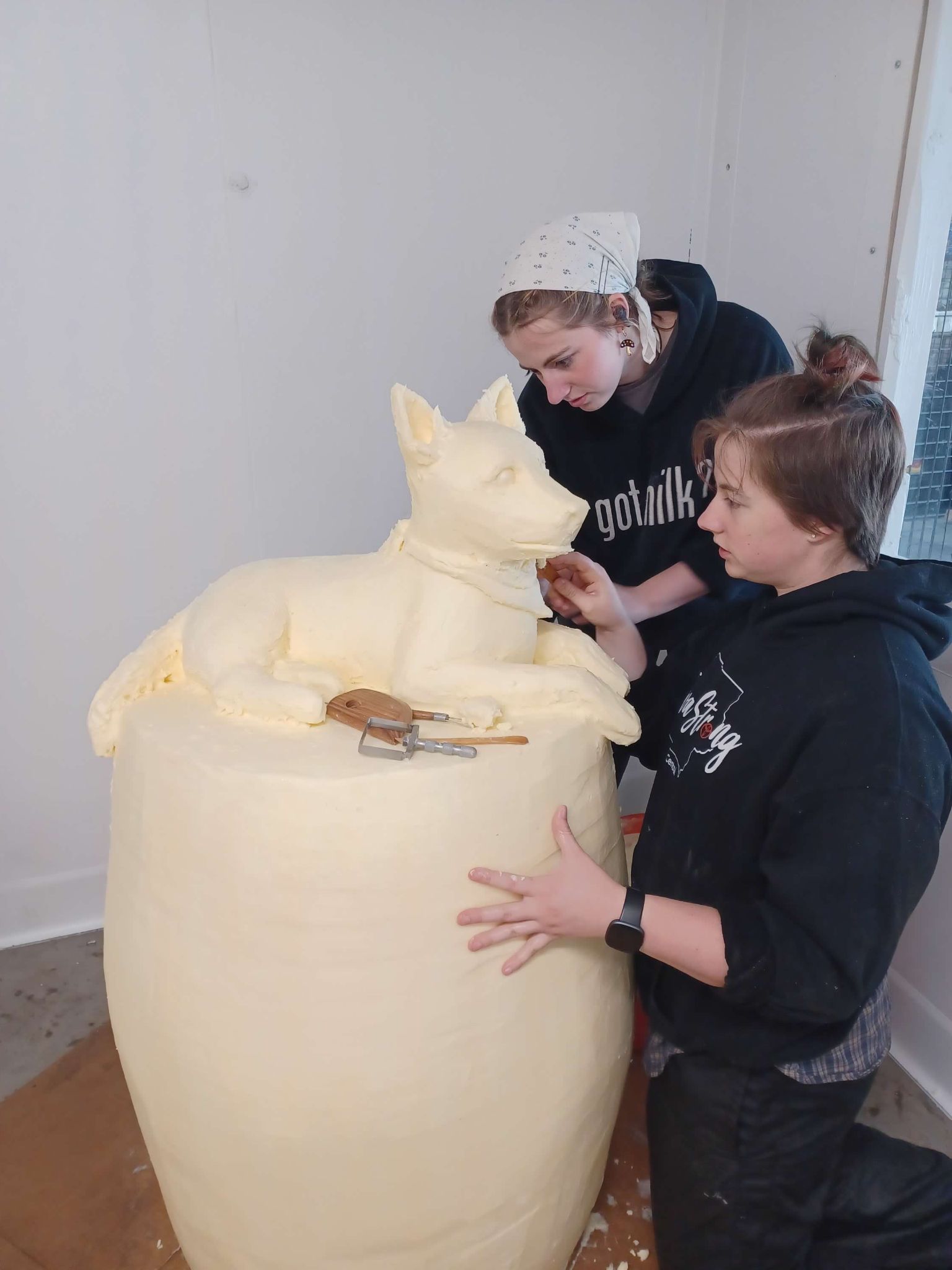 Hannah and Grace Pratt sculpting butter dog