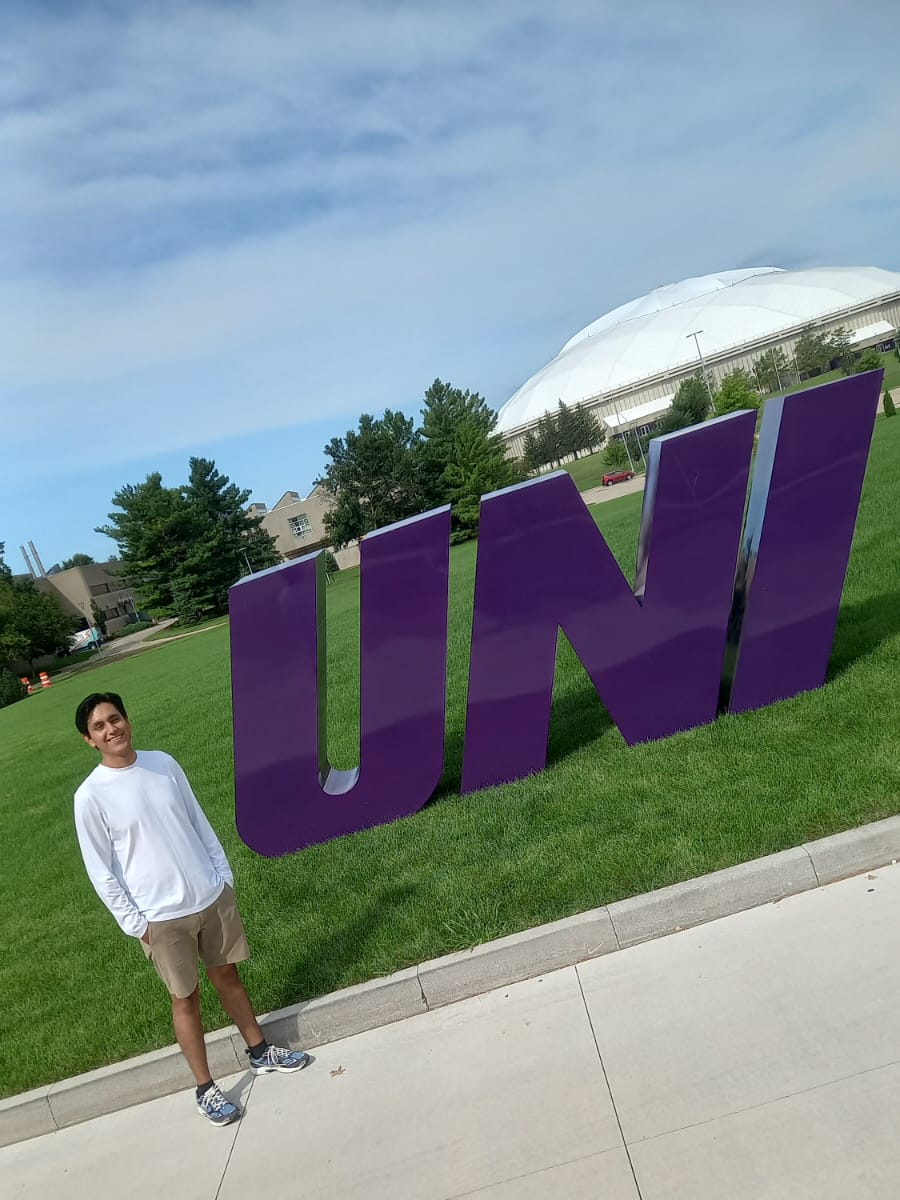 Daniel Chapilliquén in front of UNI sign