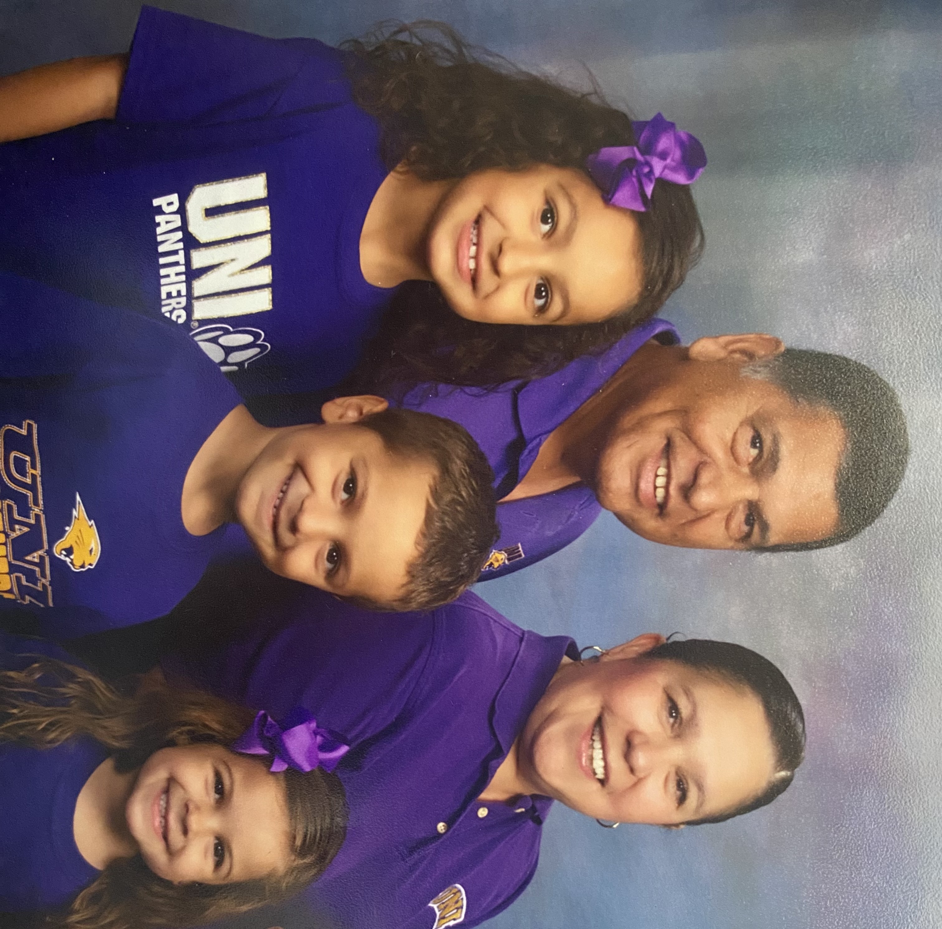 Rita and Roland Carrillo with granddaughter Isabella and her two siblings, all wearing Panther gear