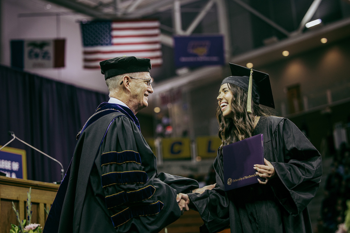 UNI grad shaking hands with President Nook at Commencement