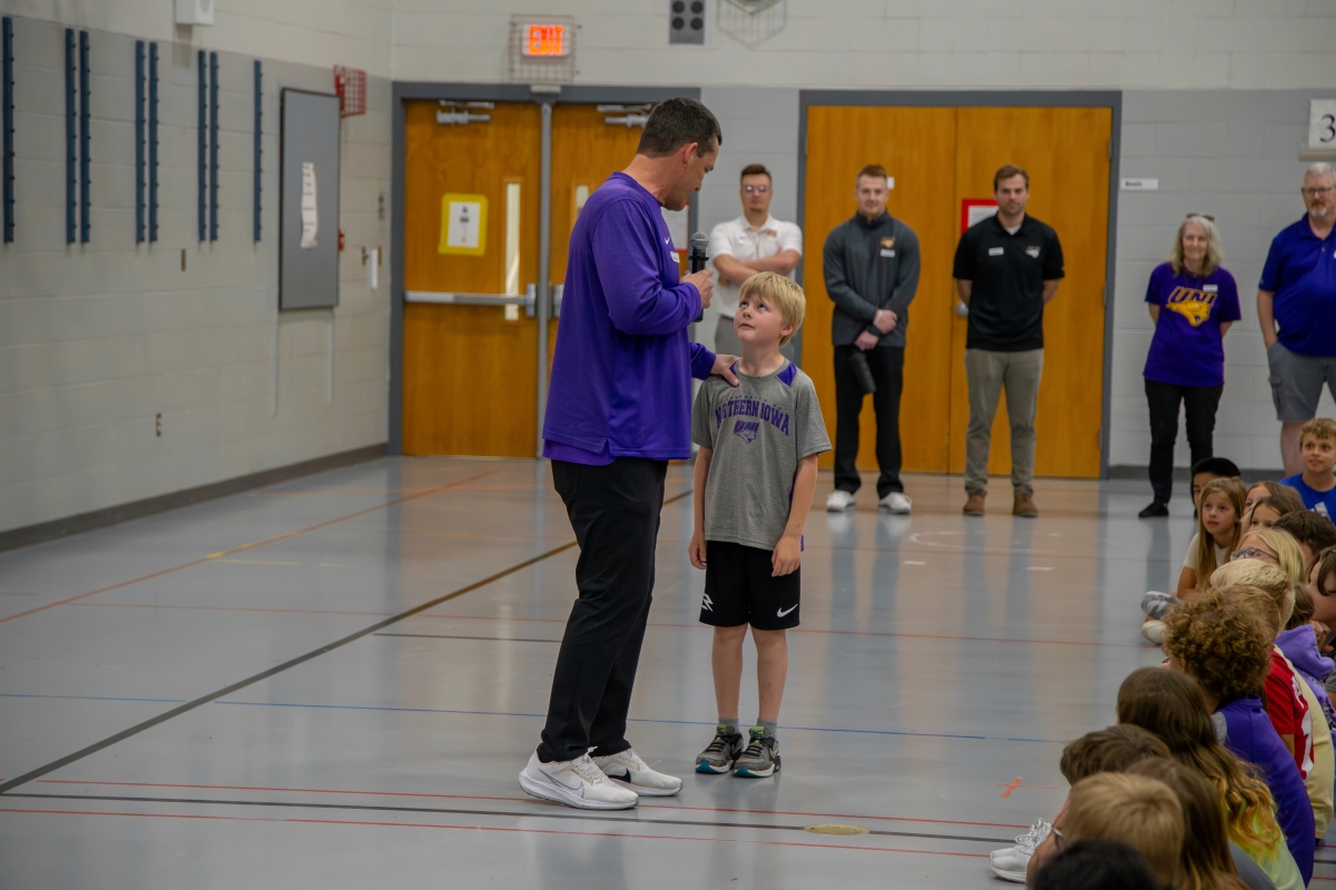 Coach Ben Jacobson talking to elementary student