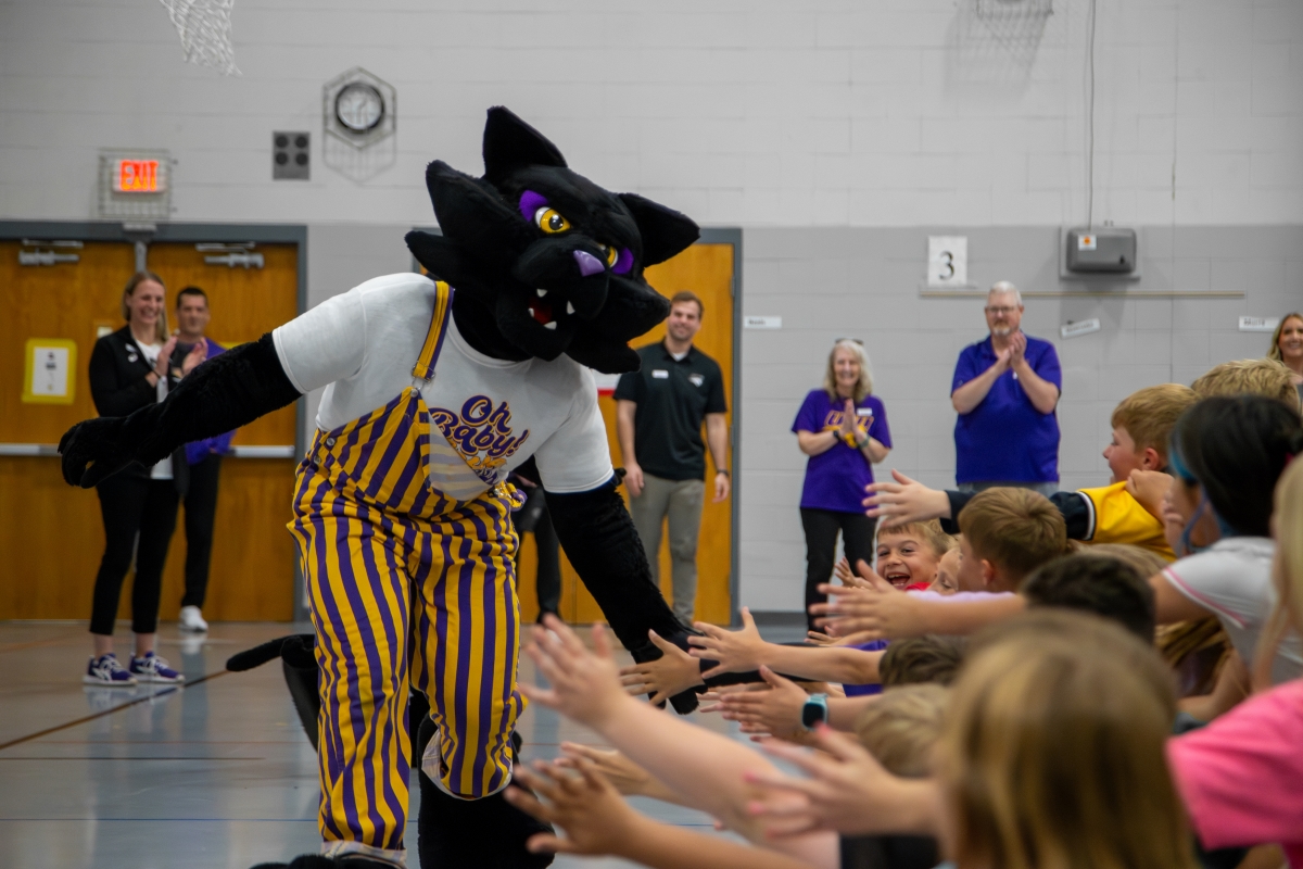 TC giving elementary school students high-fives