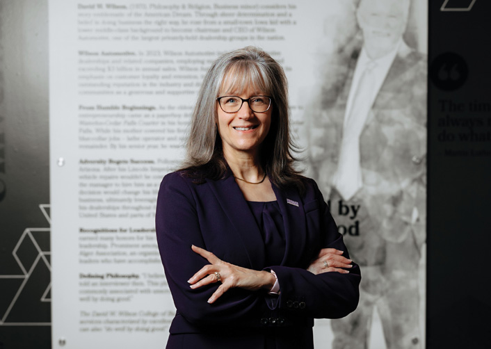 Leslie Wilson stands in front of David Wilson tribute