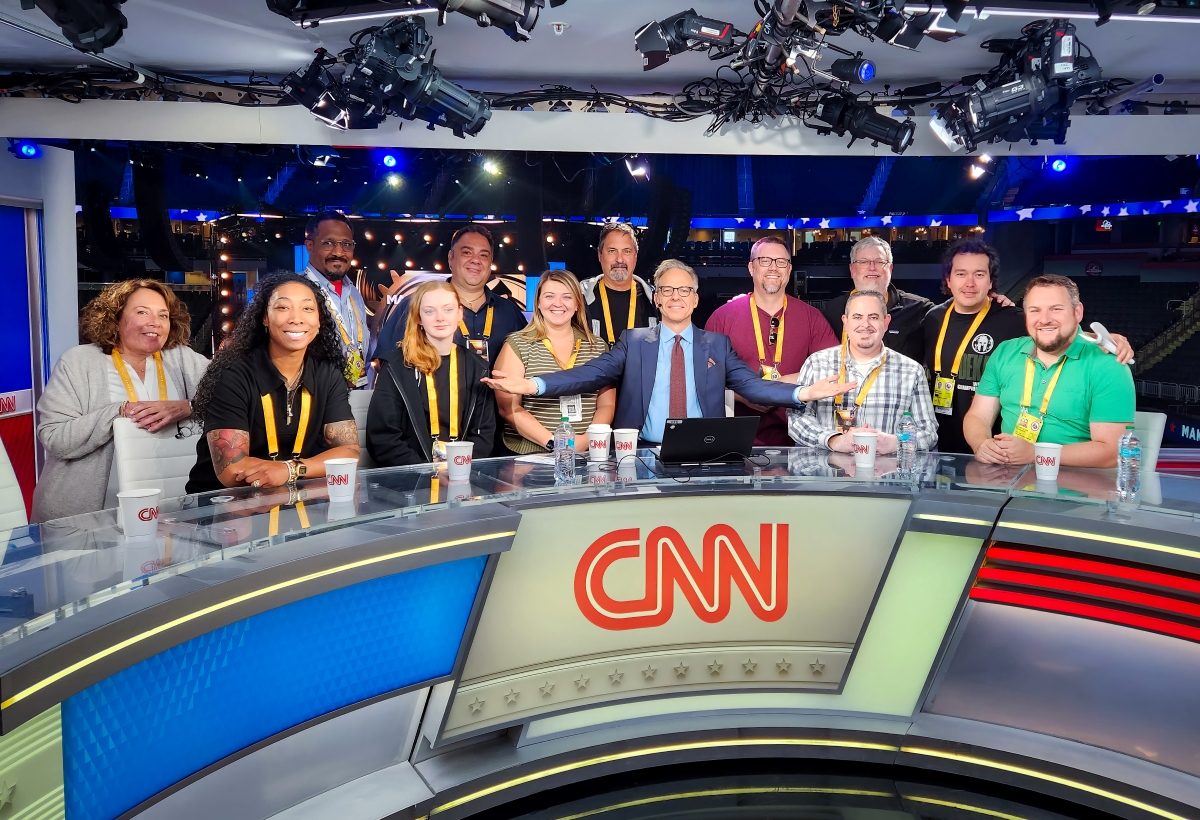 Samantha Kaster with her team and Jake Tapper behind CNN desk