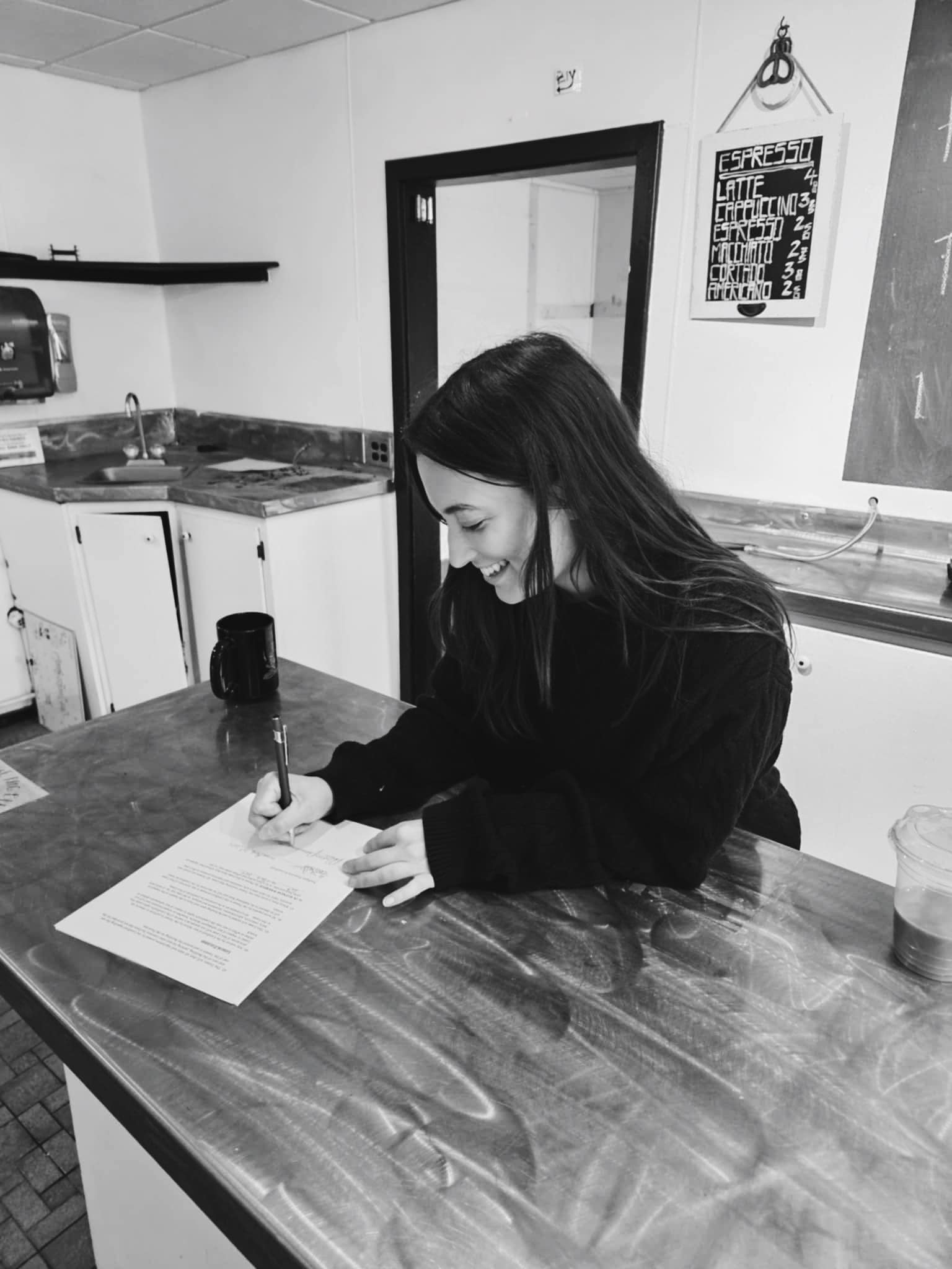 Maddie Palmersheim signing the lease to her new location for her bakery.