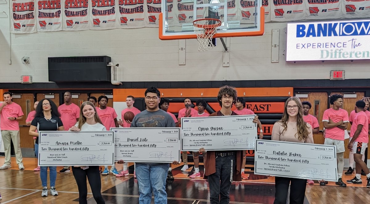 Scholarship recipients holding up big checks