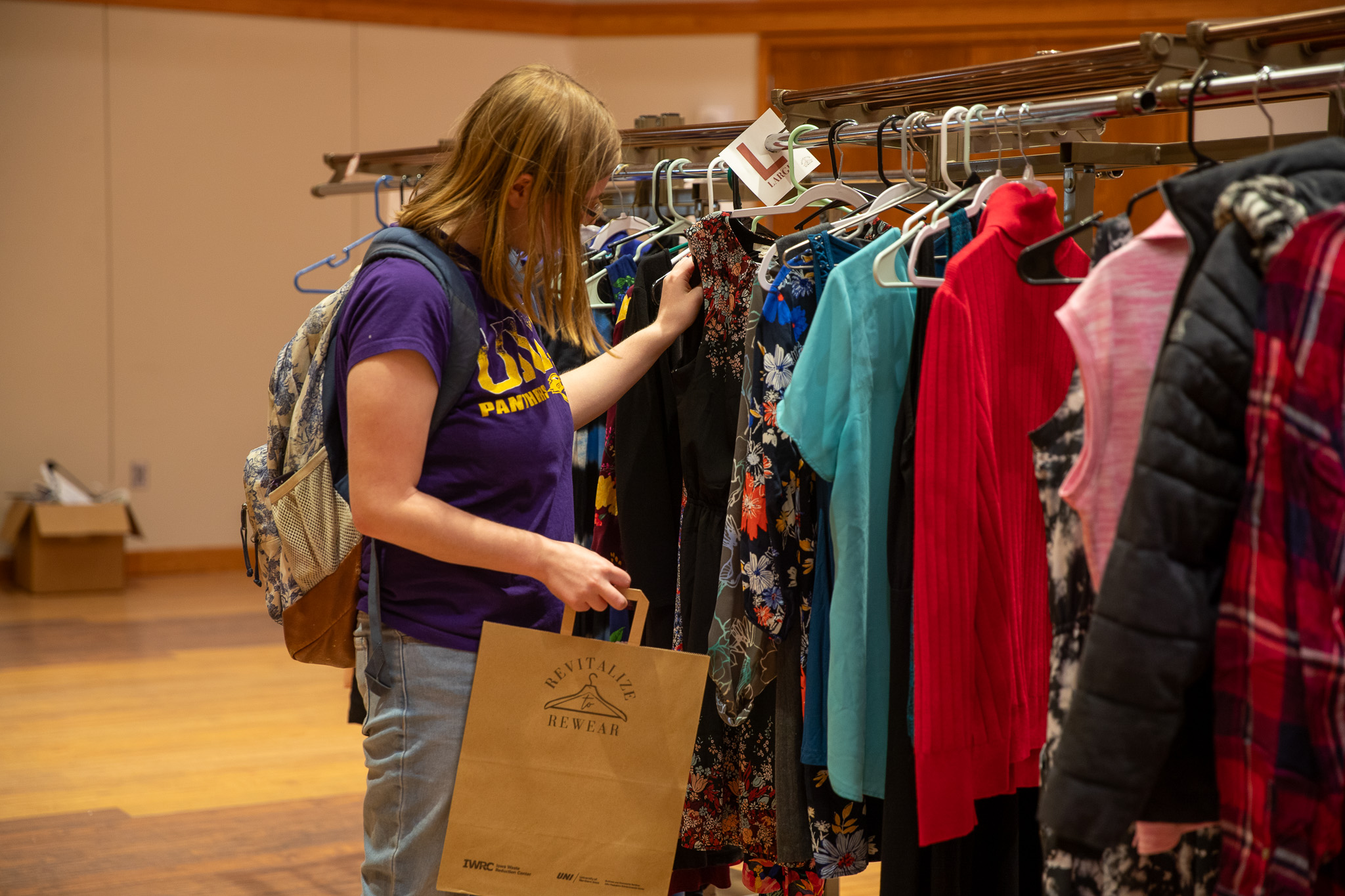Student browses clothing rack at Rummage Rampage event