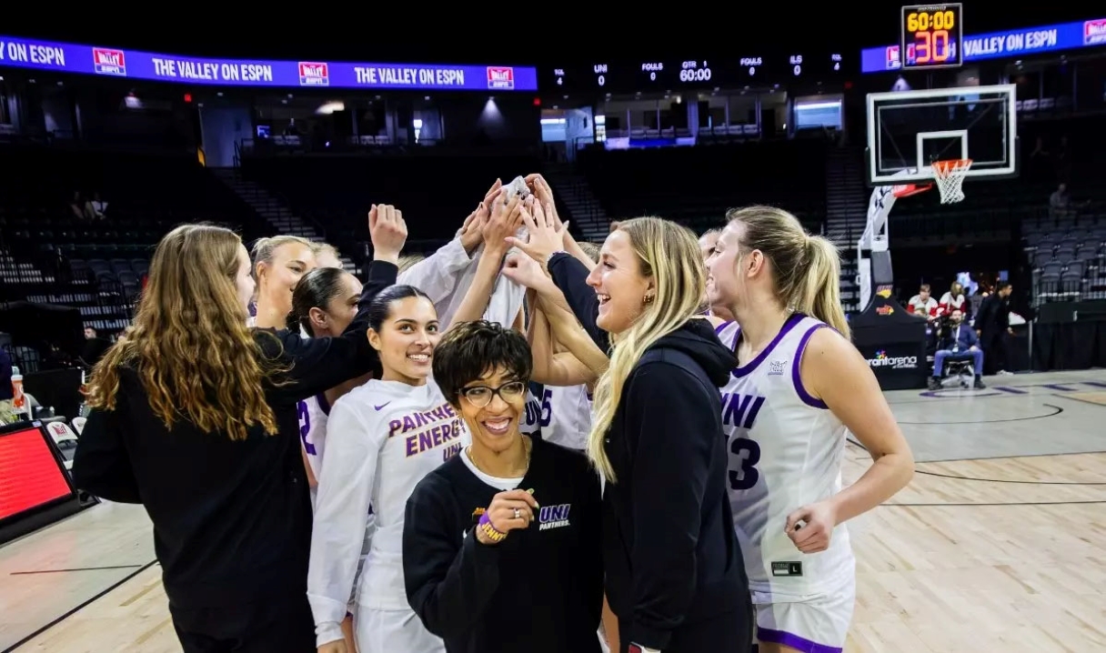 UNI women's basketball team with Coach Tanya Warren in a huddle