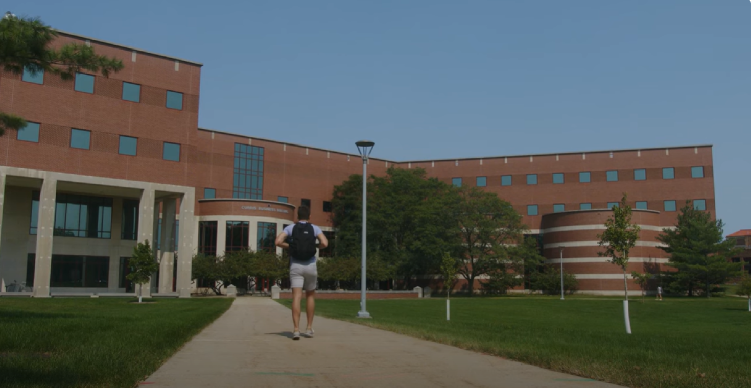 Student walking in front of Curris Business Building