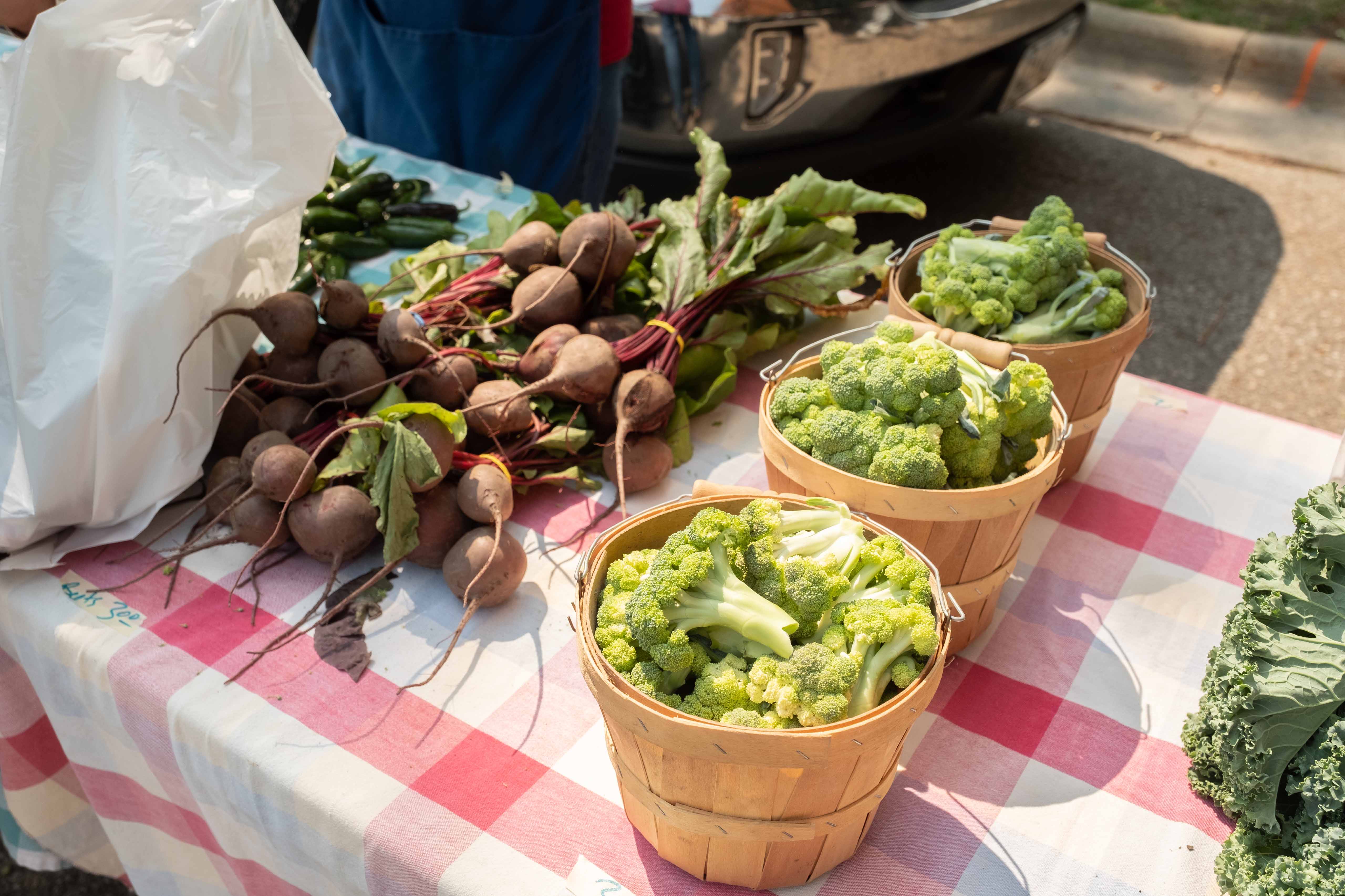 Baskets of vegetables on a vendor table.