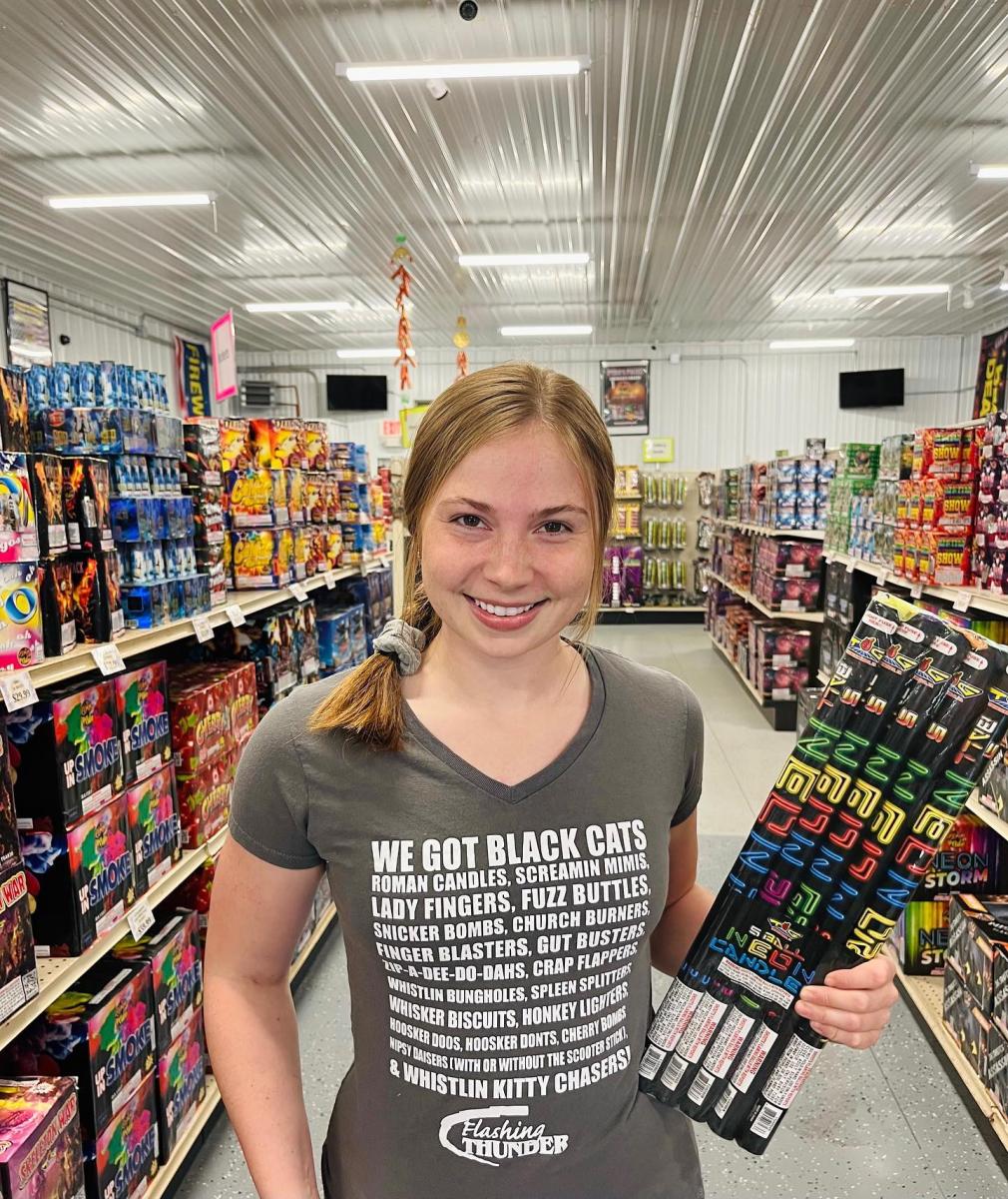 Kate Mostek holding a firework in a store