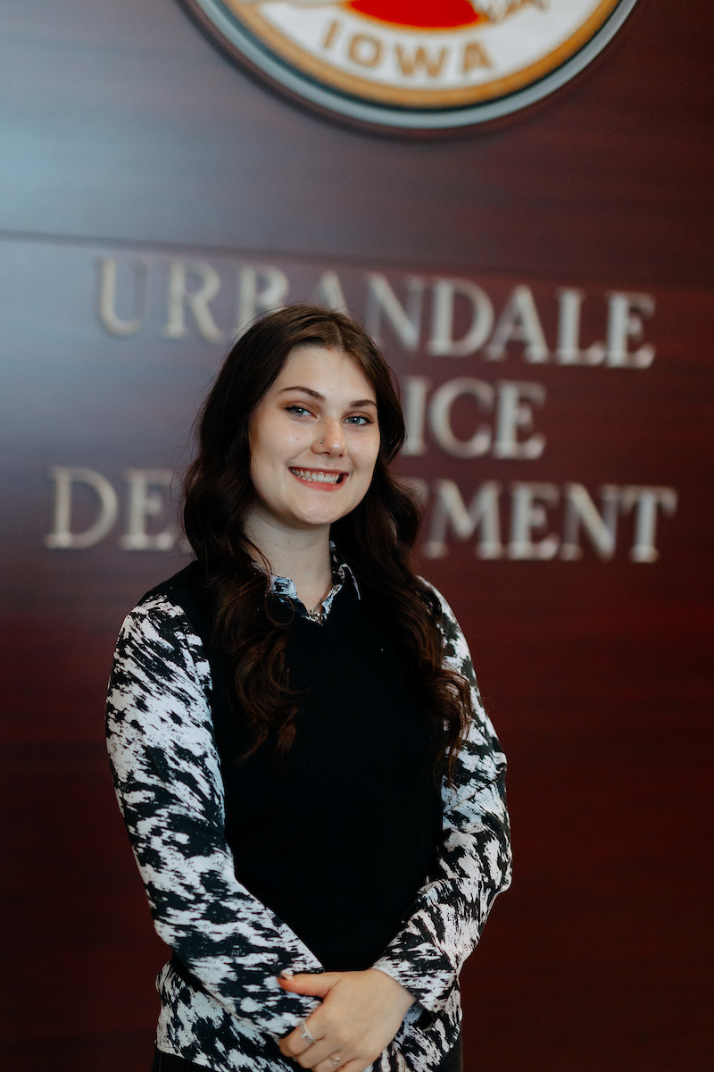 Katelyn Bakker standing in front of an Urbandale Police Department sign