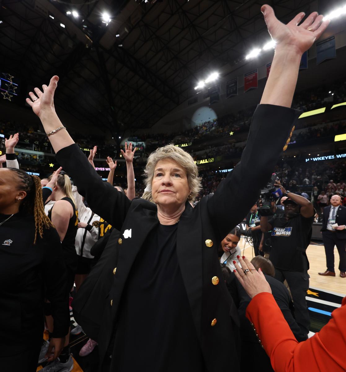 Lisa Bluder with her hands up in celebration