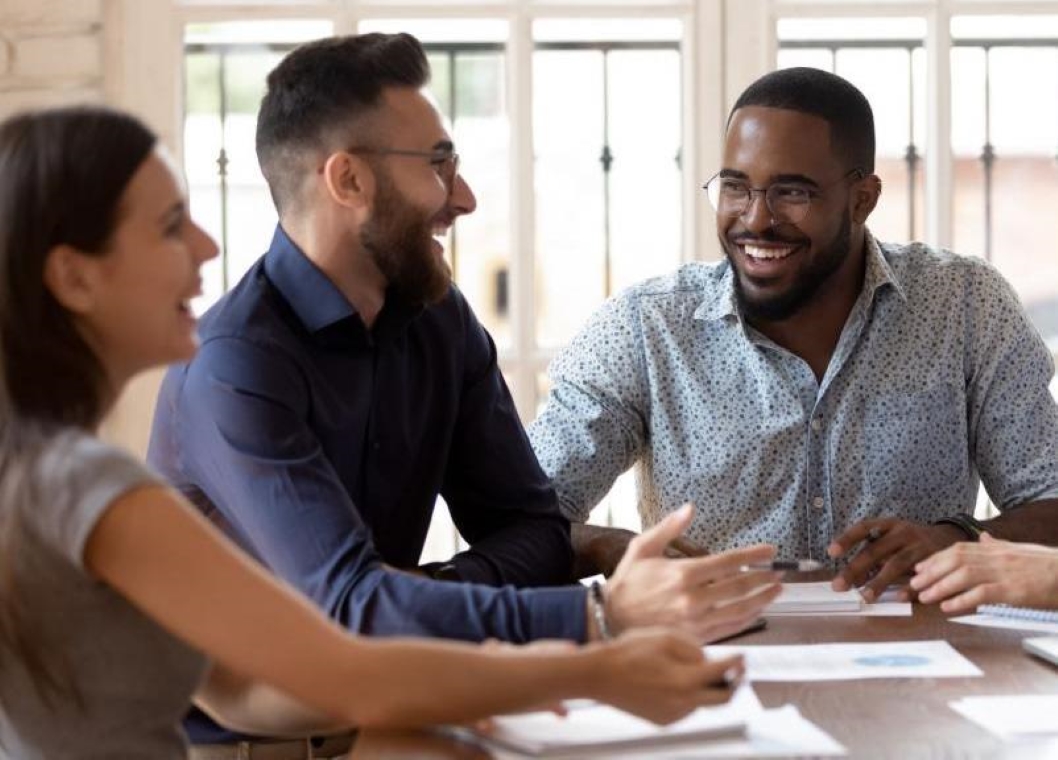 Three coworkers at a table, talking