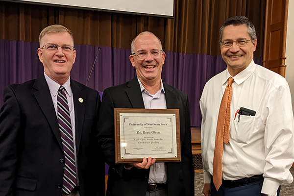 Olsen (center) pictured with President Nook (left) and Provost Herrera (right).