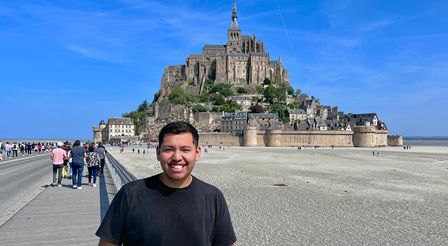 JuanDaniel poses in front of Abbaye du Mont Saint-Michel