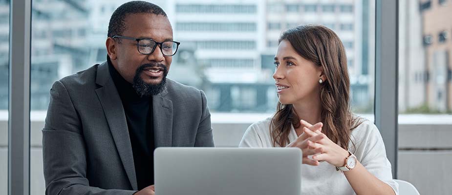 People discussing something on their laptop