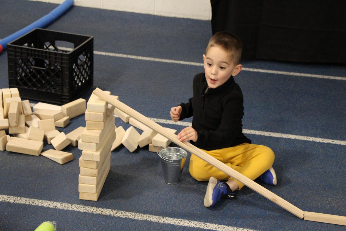 Child building ramps and pathways at the Cedar Valley STEM Festival