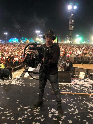 Ben Hagarty on stage at a concert with a video camera