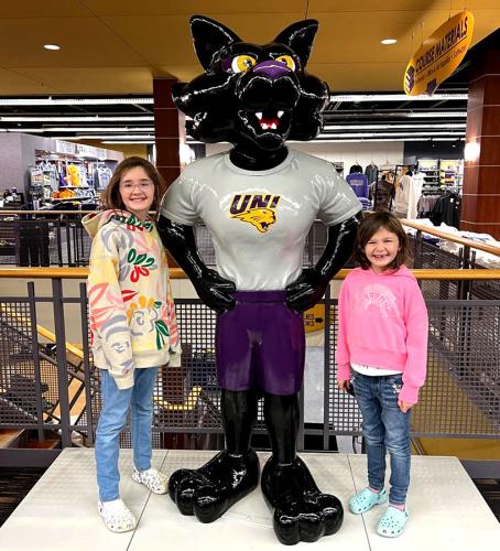 Heather Harbachs daughters pose with statue of UNI mascot TC.