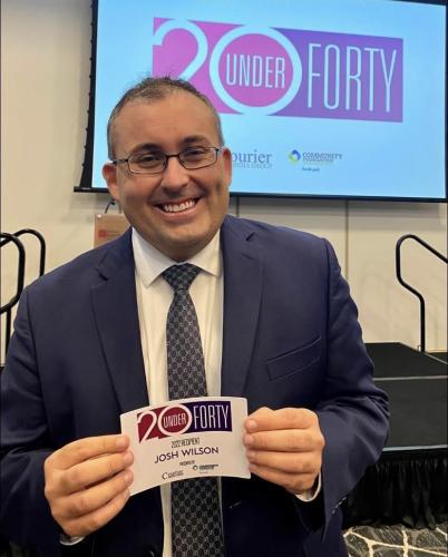 Josh Wilson holding 20 Under 40 name tag