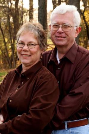 Pat Van Sickel and her late husband, John pose together outdoors 