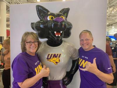 Brenda Roe-Weaver and Jesse Bawek with TC statue at UNI booth