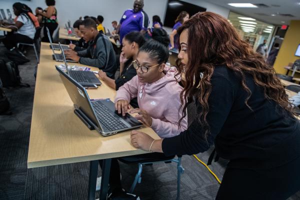 An educator works with a high school student