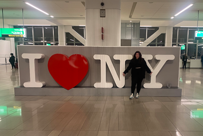 student standing in front of I love NY sign