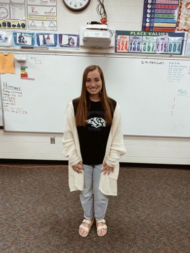 Reegan Zinkula standing in front of a white board in her classroom