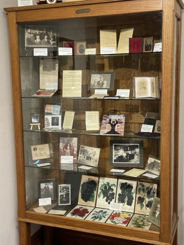 Museum display with photos and letters inside a cabinet