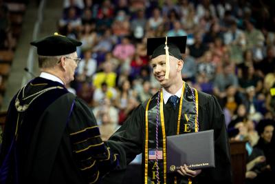 Graduate shakes hands with President Nook at Commencement