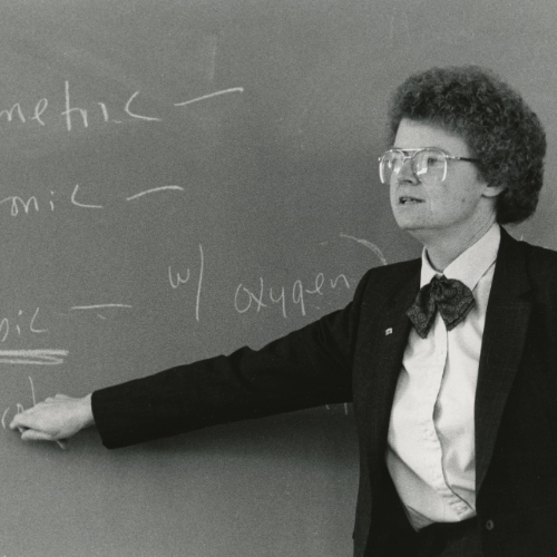 Patricia Geadelmann teaching in front of a chalkboard in 1988.
