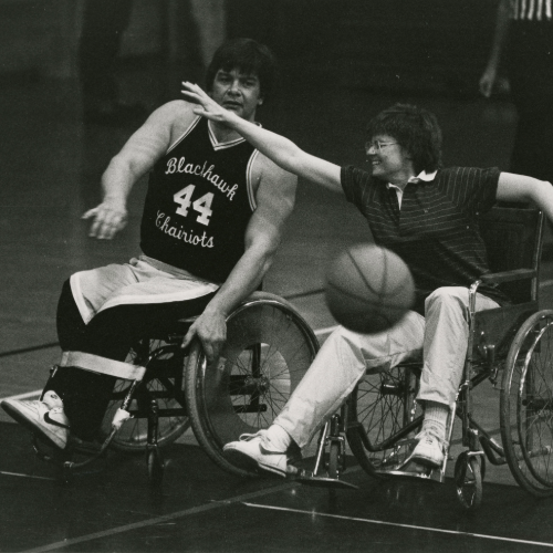Patricia Geadelmann and Ron Anderson playing basketball in wheelchairs.