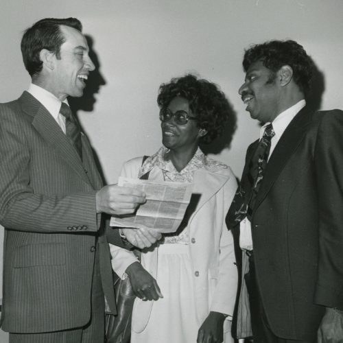 Grassley discussing papers with two people. 