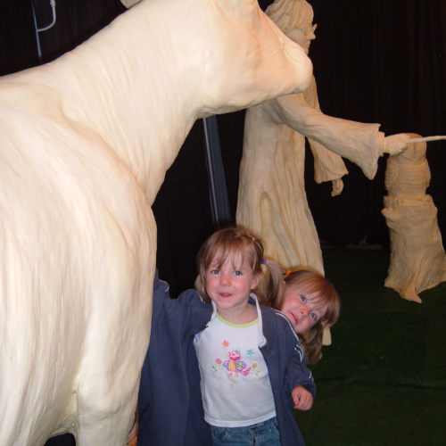 Grace and Hannah as children standing with the butter cow.
