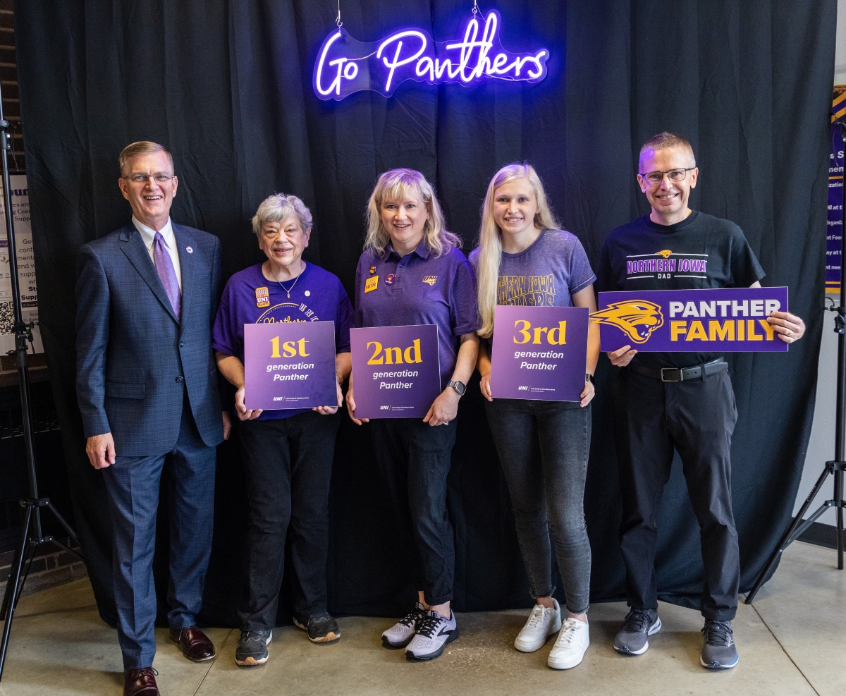 Fowler family posing with President Nook with first, second and third generation Panther signs