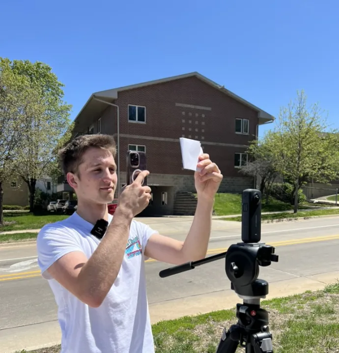 Zach Rogers taking a photo of a historic image using his phone