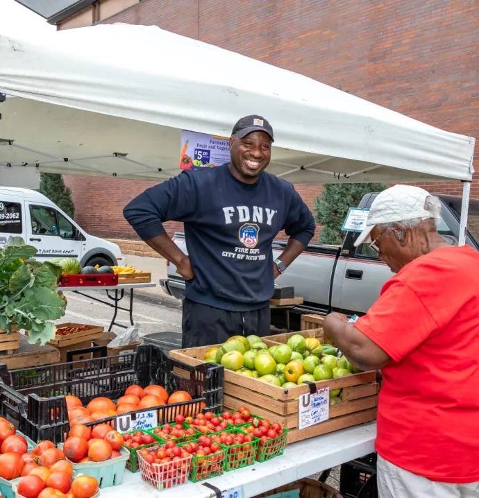 Customer selecting produce at farmers market