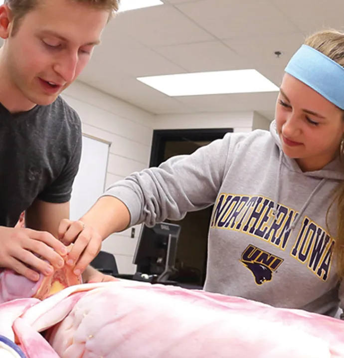 Two UNI students working with a syndaver