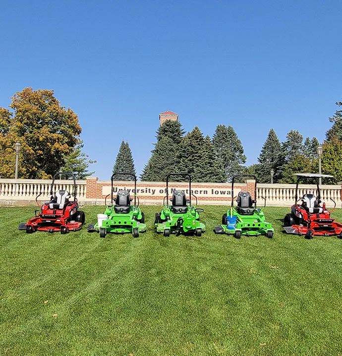 Battery-powered mowers lined up on campus. 