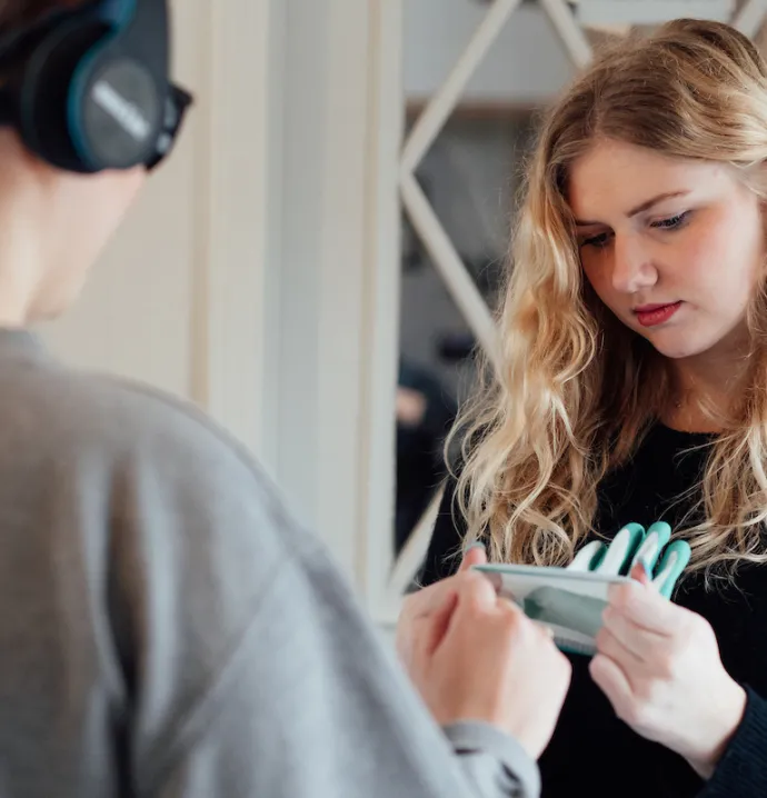 Student helps dementia simulation attendee put on gloves